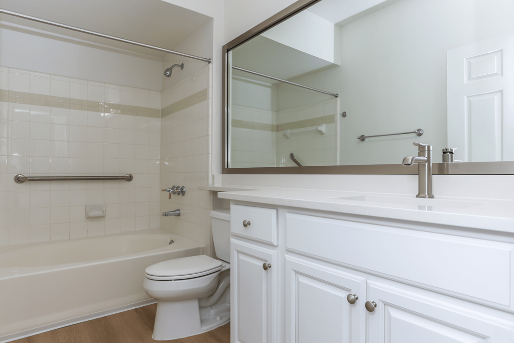 A white bathroom with a toilet, sink, and bathtub.